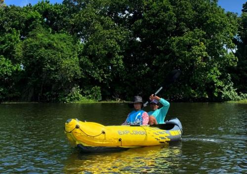 two people in a banana boat in the water at Laguna Rosa Glamping in Coveñas