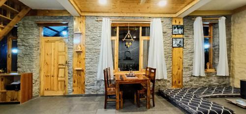 a room with a table and a bed in a room at Rustic Roots Home Stay in Nagar