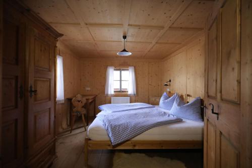 インナーヴィルグラーテンにあるAlmhütte Oberschaller bei Alfenalm - Ferienwohnungen am Bergの木造家屋内のベッドルーム(ベッド付)