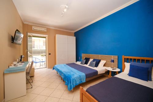 - une chambre avec 2 lits et un mur bleu dans l'établissement Midnight in Vatican, à Rome