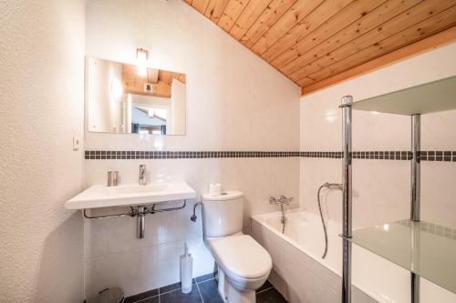 une salle de bain avec toilettes, lavabo et baignoire dans l'établissement Chalet Beauséjour, à Morzine