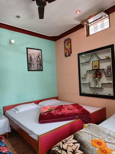a bedroom with two beds and a mirror at gaurav home stay in Barkot