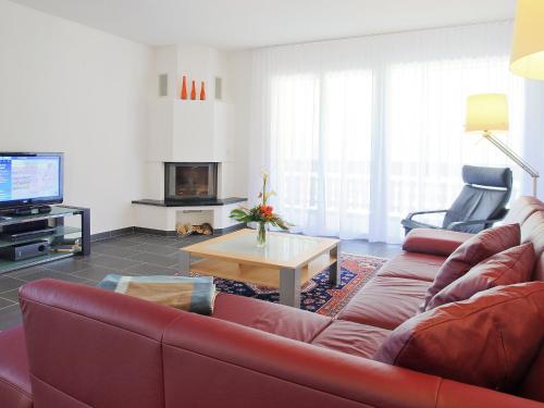 a living room with a red couch and a table at Apartment B33 by Interhome in Leukerbad