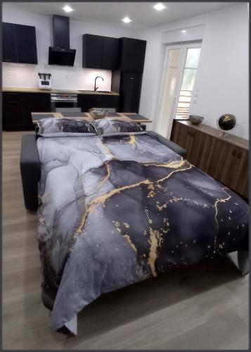 - une chambre avec un lit doté d'une couette en noir et or dans l'établissement Sur la rive du Lac, à Orbey