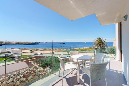 balcón con mesa, sillas y vistas al océano en Aparthotel Ferrer Skyline en Ciutadella