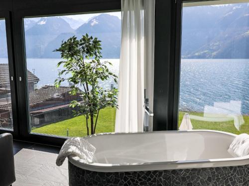 a bath tub in a room with a large window at Holiday Home Villa am See 3 by Interhome in Sisikon
