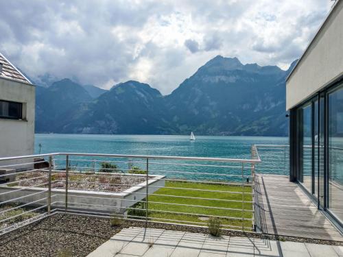 a balcony with a view of a lake and mountains at Holiday Home Villa am See 3 by Interhome in Sisikon