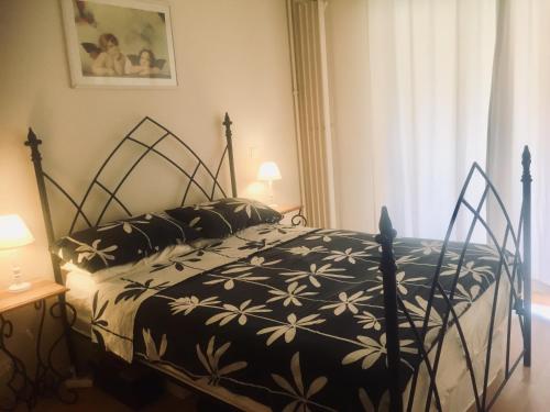 a black and white bed in a room with a window at A charming apartment in the heart of the French Riviera in Mandelieu-la-Napoule