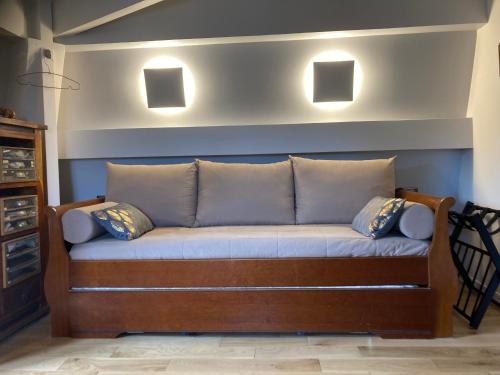 a couch with pillows on it in a room at Séjour à la Châtaigneraie in Rueil-Malmaison