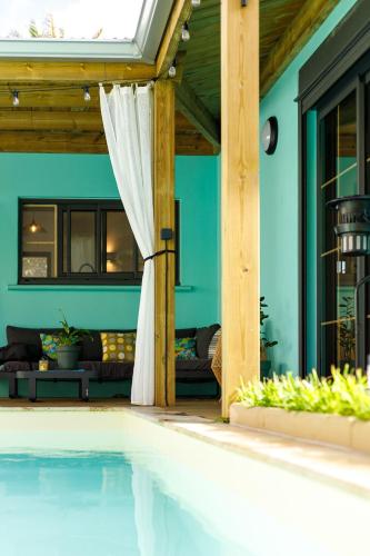 a swimming pool in a house with a blue wall at maison de vacances Althéa in Saint-Pierre