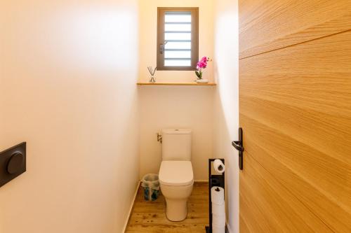 a small bathroom with a toilet and a window at maison de vacances Althéa in Saint-Pierre