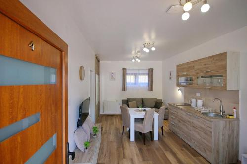 a kitchen and a living room with a table and a kitchen and a living room at AnRo in Palić