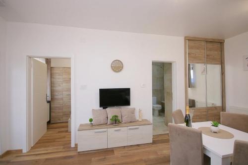 a living room with a flat screen tv on a wall at AnRo in Palić