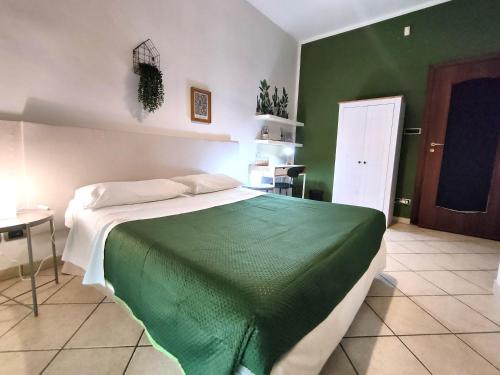 - une chambre avec un grand lit et une couverture verte dans l'établissement Casa Viola a 900 mt dalla Staz. Centrale, à Pescara