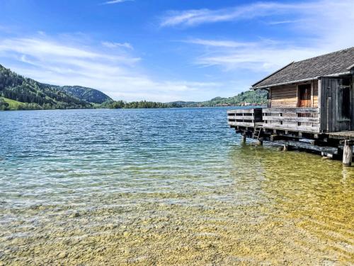 a house on a dock on a lake at Holiday Home Tiny Haus Glockenalm-Haus Hakuna Matata by Interhome in Aurach