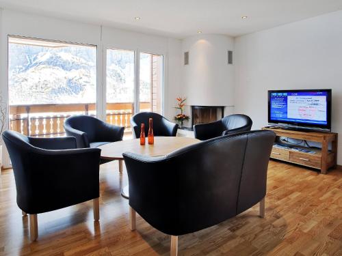 a dining room with a table and chairs and a television at Apartment Iris B-5 by Interhome in Leukerbad