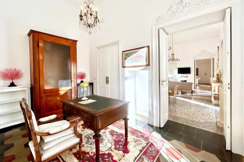 Habitación con escritorio, silla y sala de estar. en Luxury Boutique Home - Premium center location - Mole Antonelliana view - 3 Bedroom with Balcony - Grand Maison, en Turín