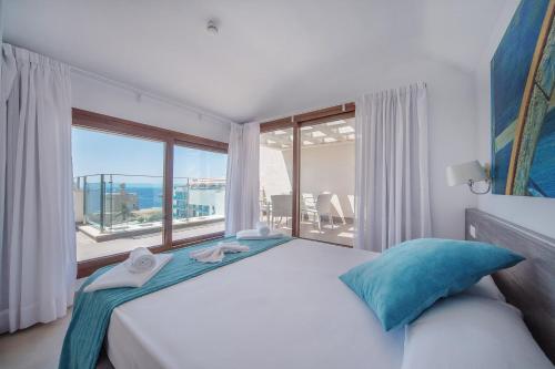 a bedroom with a large bed with a large window at Aparthotel Caprice Skyline in Ciutadella