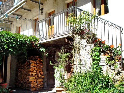 a building with a balcony and a staircase with flowers at Apartment Casa Strecce - App- 2 by Interhome in Crana