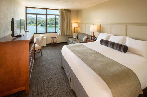 ein Hotelzimmer mit einem großen Bett und einem TV in der Unterkunft The Terrace Hotel at Lake Junaluska in Lake Junaluska