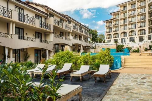 a row of chairs in front of buildings at The Cliff Hotel and Holiday Apartments by Flat Mаnаger in Obzor