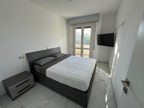 ein Schlafzimmer mit einem Bett und einem TV in der Unterkunft Elegante appartamento a due passi dal mare in Rimini