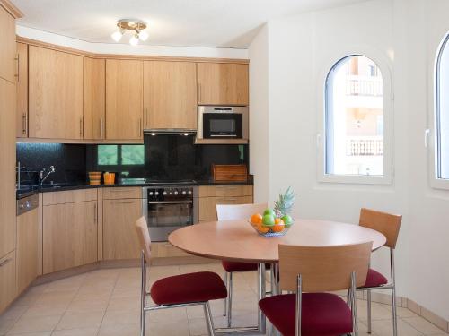 una cocina con mesa de madera y sillas y un asterisco en Apartment Iris A-1 by Interhome en Leukerbad