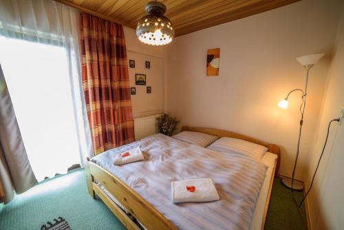 a bedroom with a bed with two towels on it at Pension Arberwald in Bayerisch Eisenstein