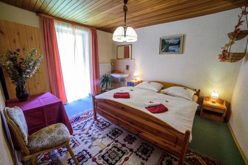 a bedroom with a large bed with red towels on it at Pension Arberwald in Bayerisch Eisenstein