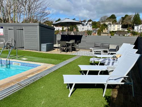 een zwembad met ligstoelen en een zwembad bij Atlantis Holiday Apartments in Torquay