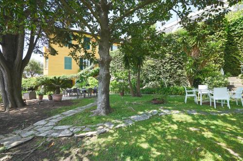 a garden with a table and chairs under a tree at Villa Margherita in Levanto