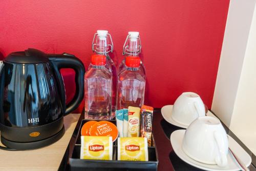 a table with two bottles of water and a coffee maker at Hotel Midtown Ratsada in Phuket Town