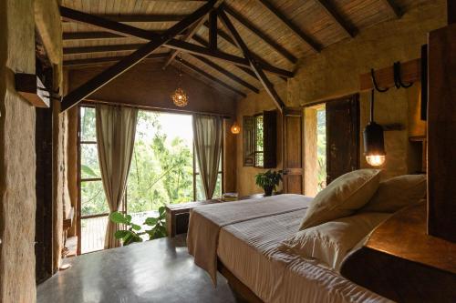 ein Schlafzimmer mit einem Bett und einem großen Fenster in der Unterkunft Cabañas en la montaña Viga Vieja in San Peregrino