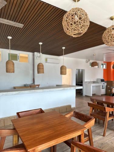 Un comedor con mesas y sillas de madera. en Oneiro Suites with Sea View, en Mahahual