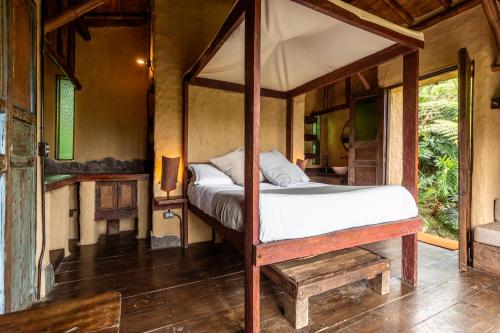 a bedroom with a canopy bed in a room at Cabañas en la montaña Viga Vieja in San Peregrino