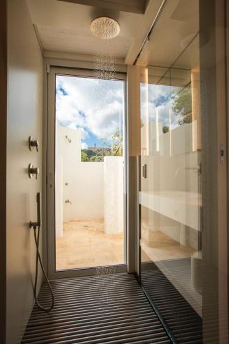 a glass door to a bathroom with a view of a room at Il Trullino in Ostuni