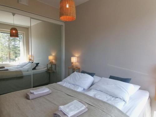 a bedroom with two beds and a large mirror at Apartment Beach & Golf Kalajoki in Kalajoki