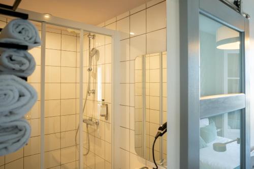 a shower in a bathroom with a glass door at Hôtel Central in Poitiers