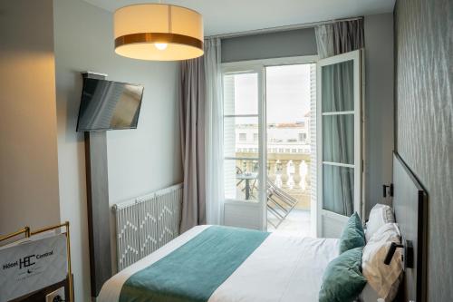 Cette chambre comprend un lit et une porte coulissante en verre. dans l'établissement Hôtel Central, à Poitiers