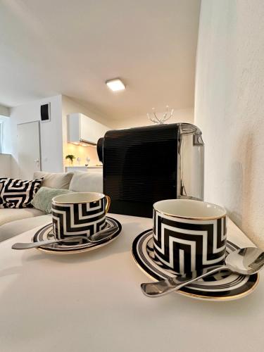 two cups and plates on a counter with a toaster at Schöne Ferienwohnung in Schottwien