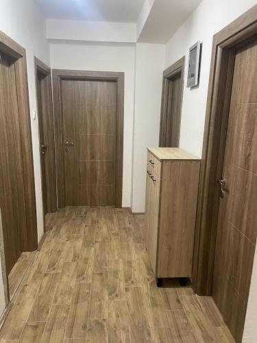 an empty room with two doors and wooden floors at Centar Apartment in Kumanovo