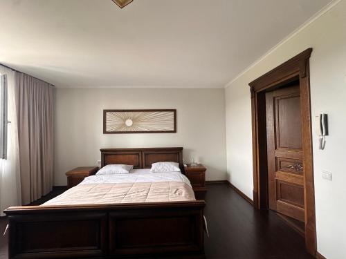 sypialnia z dużym łóżkiem z drewnianym zagłówkiem w obiekcie Едем w mieście Brzezhany