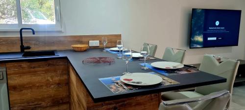 une cuisine avec une table et des verres de vin dans l'établissement Havre de paix, 5 min de la mer, à Zonza