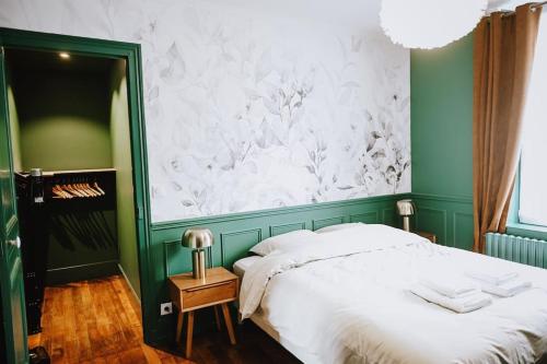 - une chambre verte et blanche avec un lit et une table dans l'établissement Suite Ernest - 2 pers, à Charleville-Mézières
