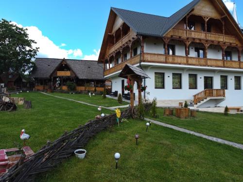 a large building with a yard with balls on the grass at Pensiunea Maramu in Breb