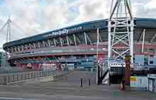 a large soccer stadium with a blue roof at Cardiff city centre apartment in Cardiff