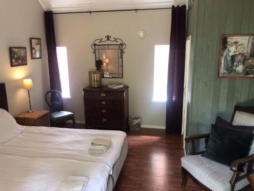 a bedroom with a bed and a chair and a mirror at Vingårdens Bed & Breakfast in Helsingborg