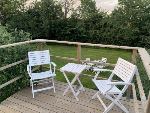 two white chairs and a table on a deck at Vingårdens Bed & Breakfast in Helsingborg