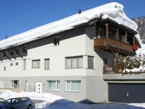 un bâtiment enneigé avec un balcon au-dessus. dans l'établissement Apartment Honegger by Interhome, à Churwalden