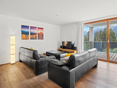 uma sala de estar com dois sofás e uma televisão em Apartment Kulm 2 by Interhome em Valbella